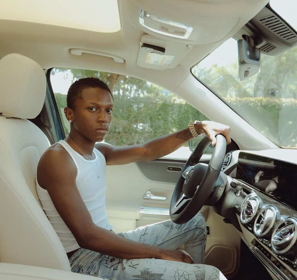 Zaire poses in his car.